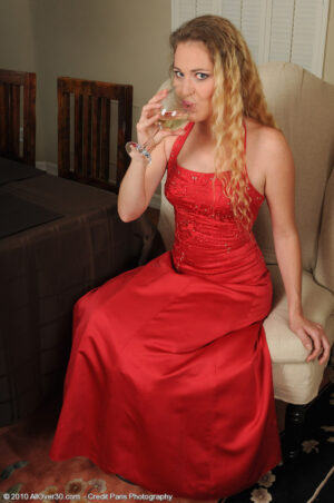Elegant blonde MILF Daisy L loses her red dress to reveal her meaty pussy lips